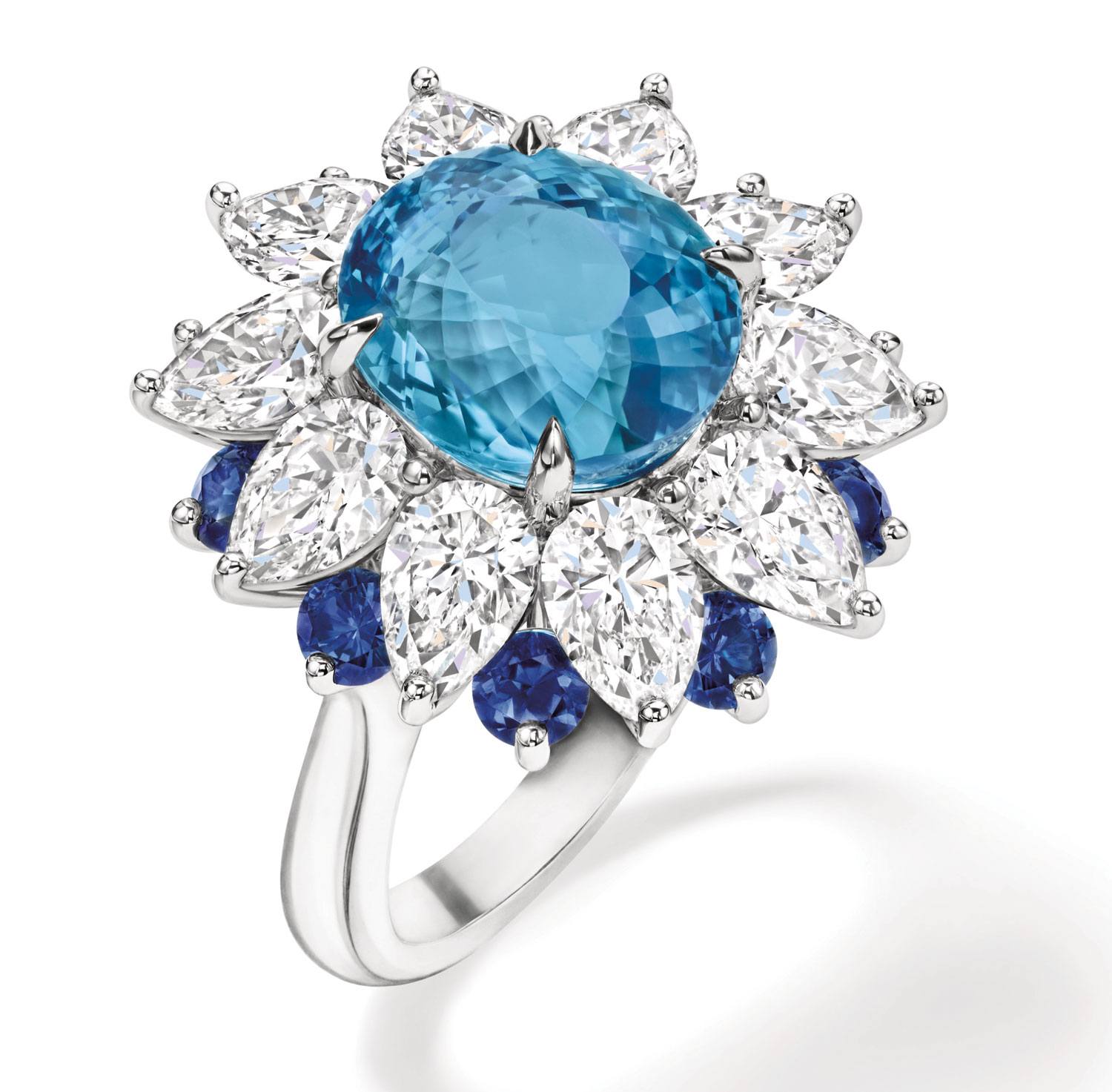 Silver ring with a large blue central gemstone, surrounded by clear marquise-cut stones and smaller round blue stones.