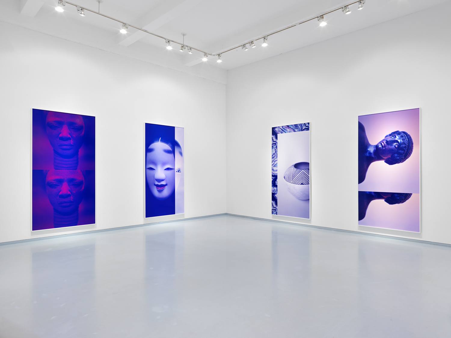 Art gallery with blue and purple-toned portraits on walls, well-lit modern interior with polished floor.