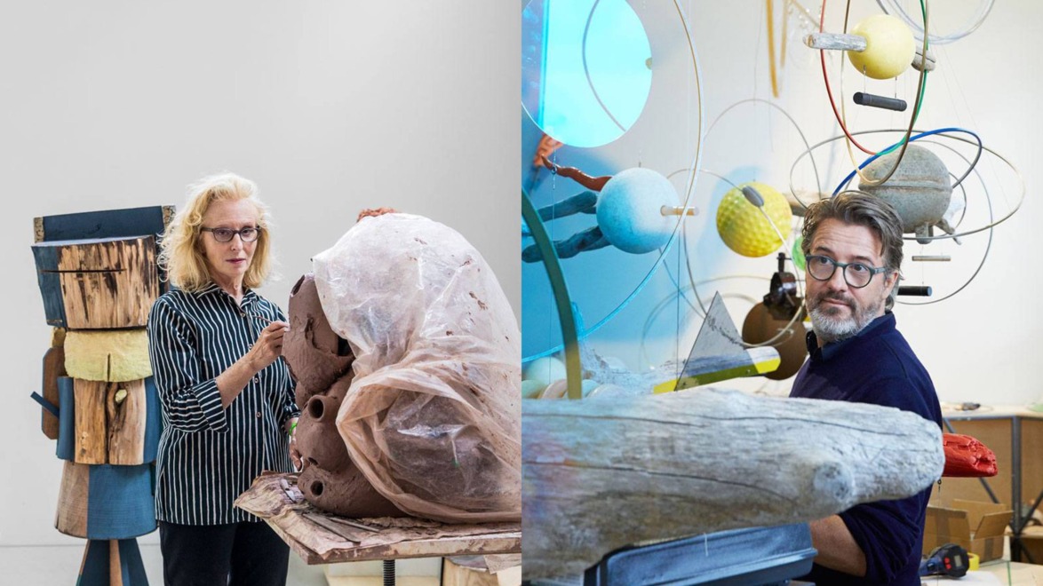 Two artists working in a studio with various sculptures and colorful abstract art pieces around them