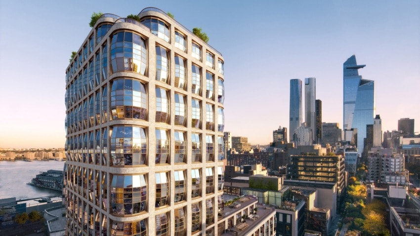 Modern cityscape with high-rise buildings and a distinctive glass-fronted structure at sunset.