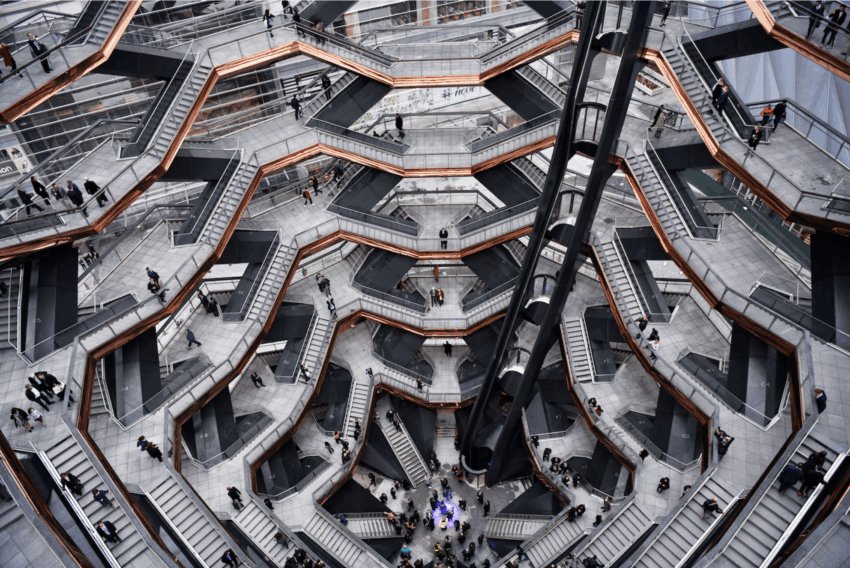 Aerial view of the Vessel structure in New York, showcasing its intricate stairways and platforms with visitors exploring.