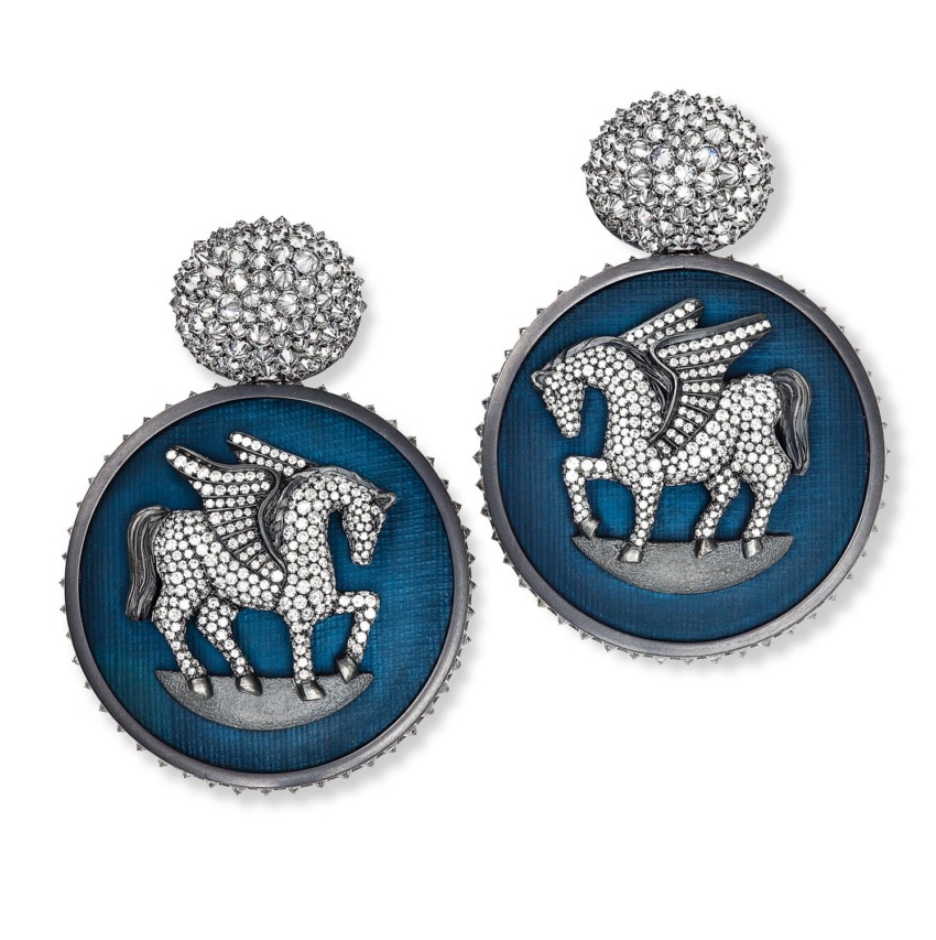 Silver earrings with a studded horse design on a blue background, featuring a round, textured top piece.