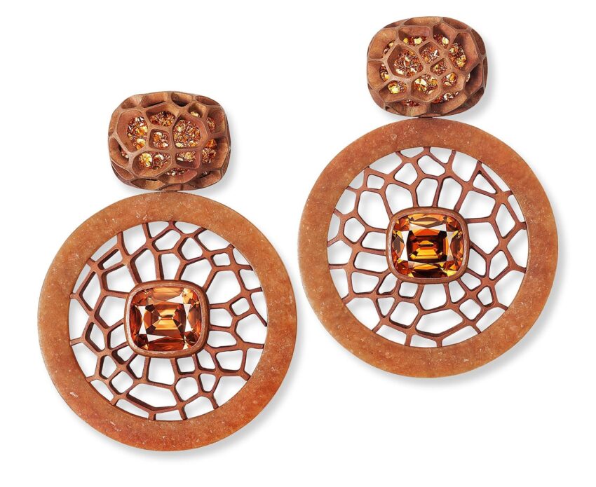 Elegant orange and brown earrings with geometric design and gemstone accents, featuring intricate openwork patterns.