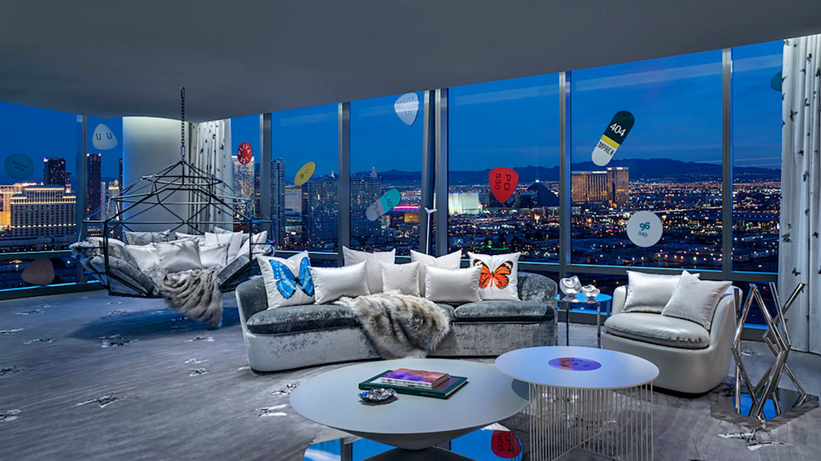 Luxurious modern living room with city skyline view, featuring elegant furniture and glass walls displaying nighttime city lights.