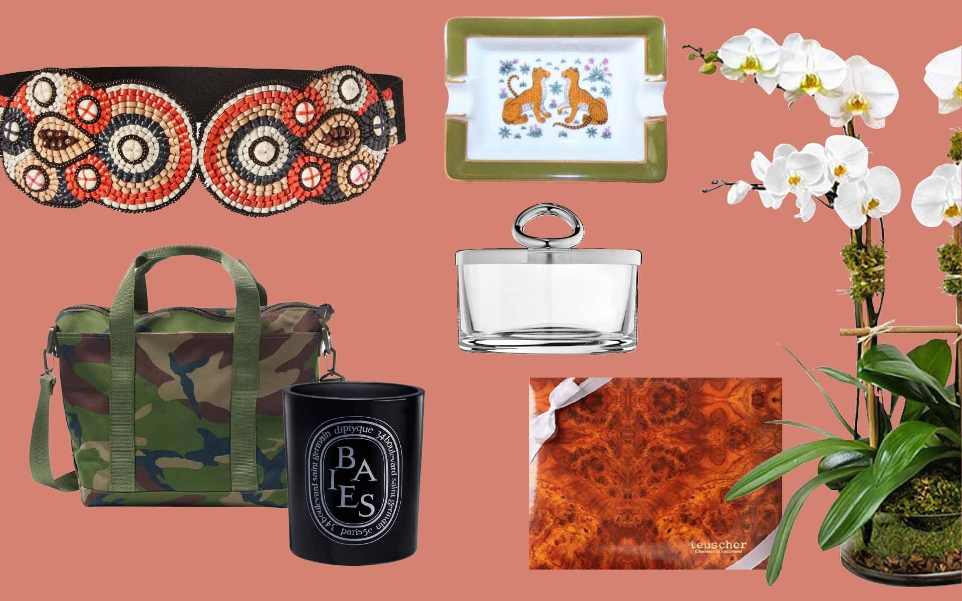 Fashionable items including a beaded mask, floral decor, candle, camo bag, and elegant serving dish on a coral background.