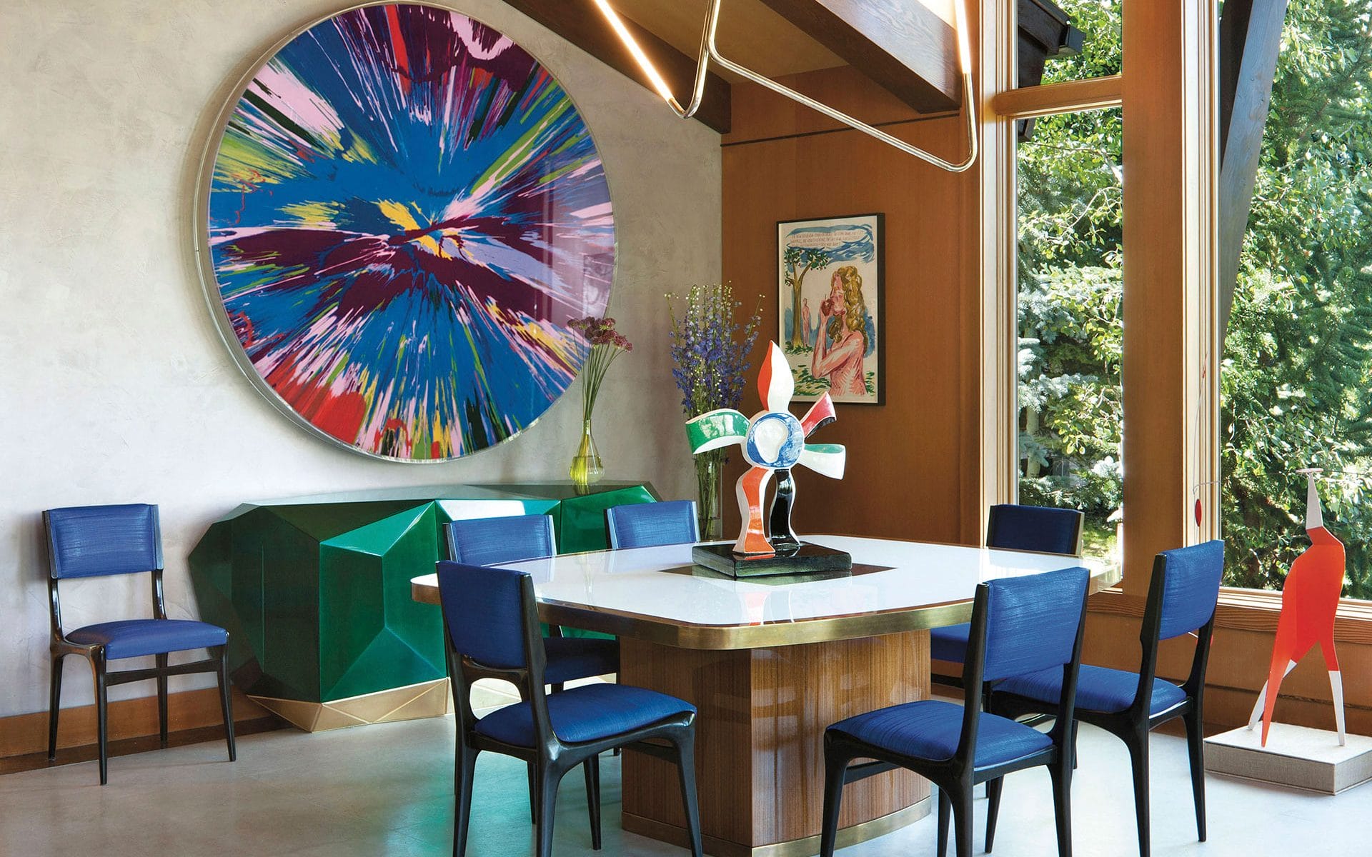 A Damien Hirst Spin painting makes a splashy statement in the dining area of Sue Hostetler’s Aspen home designed by Sara Story.
