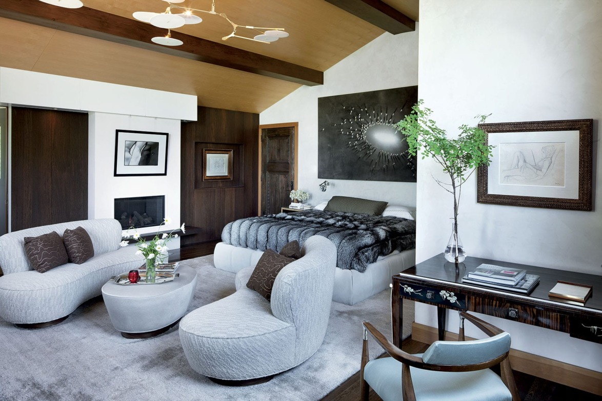 In the master suite, a Juan Genoves painting is given pride of place above the bed, which is upholstered in a suede by Edelman Leather; the Vladimir Kagan settees and ottoman were custom made. The photograph over the fireplace is by Eikoh Hosoe, while a Balthus work surmounts an Émile-Jacques Ruhlmann desk; the armchair is vintage Ib Kofod-Larsen