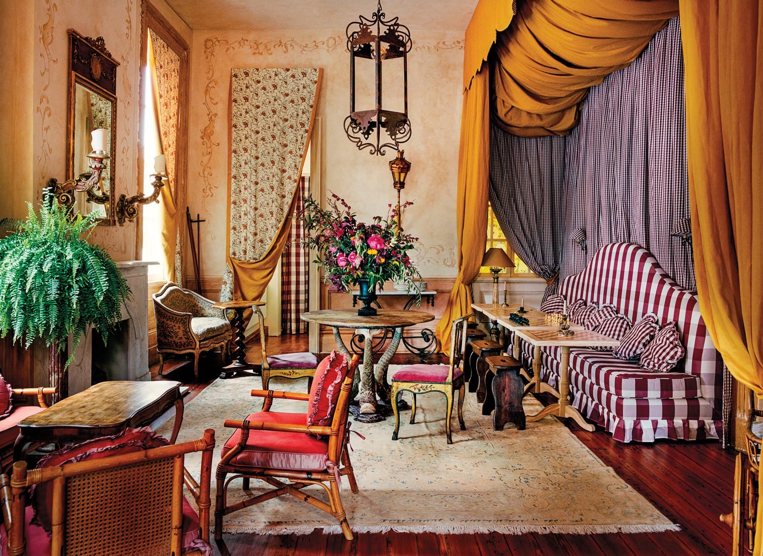 Elegant vintage living room with ornate furniture, striped sofa, floral centerpiece, and decorative curtains.