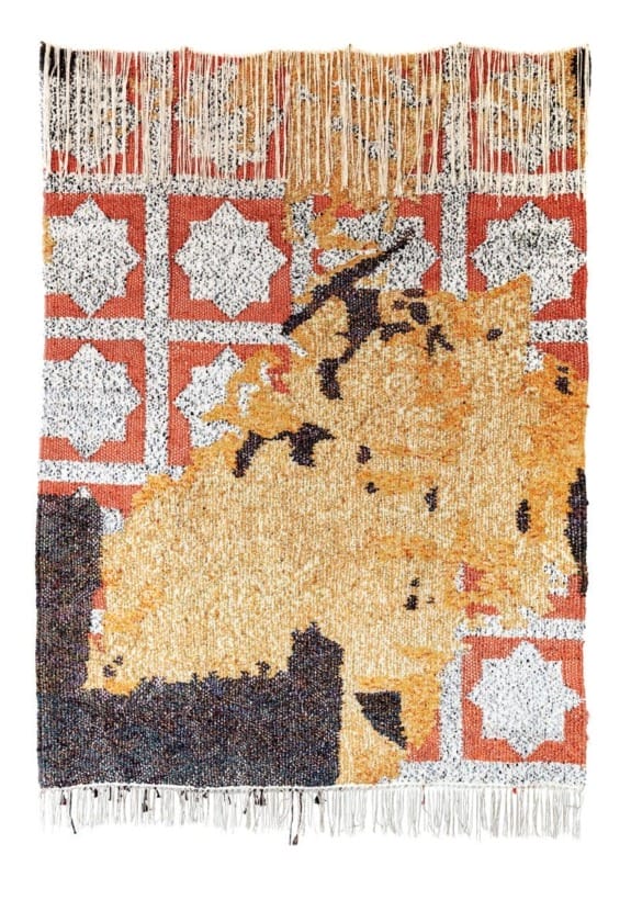 Handwoven tapestry with abstract orange and black patterns on a red and white geometric background with fringe edges