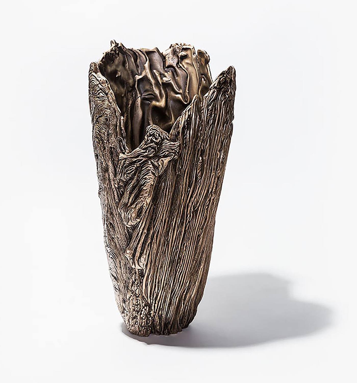 Bronze sculpture resembling a tree trunk with intricate textures and patterns, displayed on a white background.