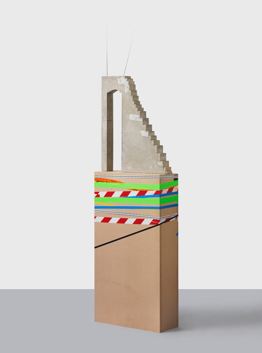 Abstract art sculpture with layered geometric shapes and colorful patterns, featuring a staircase-like structure on top.