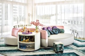 luxurious modern living room with a round sectional sofa, vibrant cushions, a swivel minibar, and large windows with sheer curtains