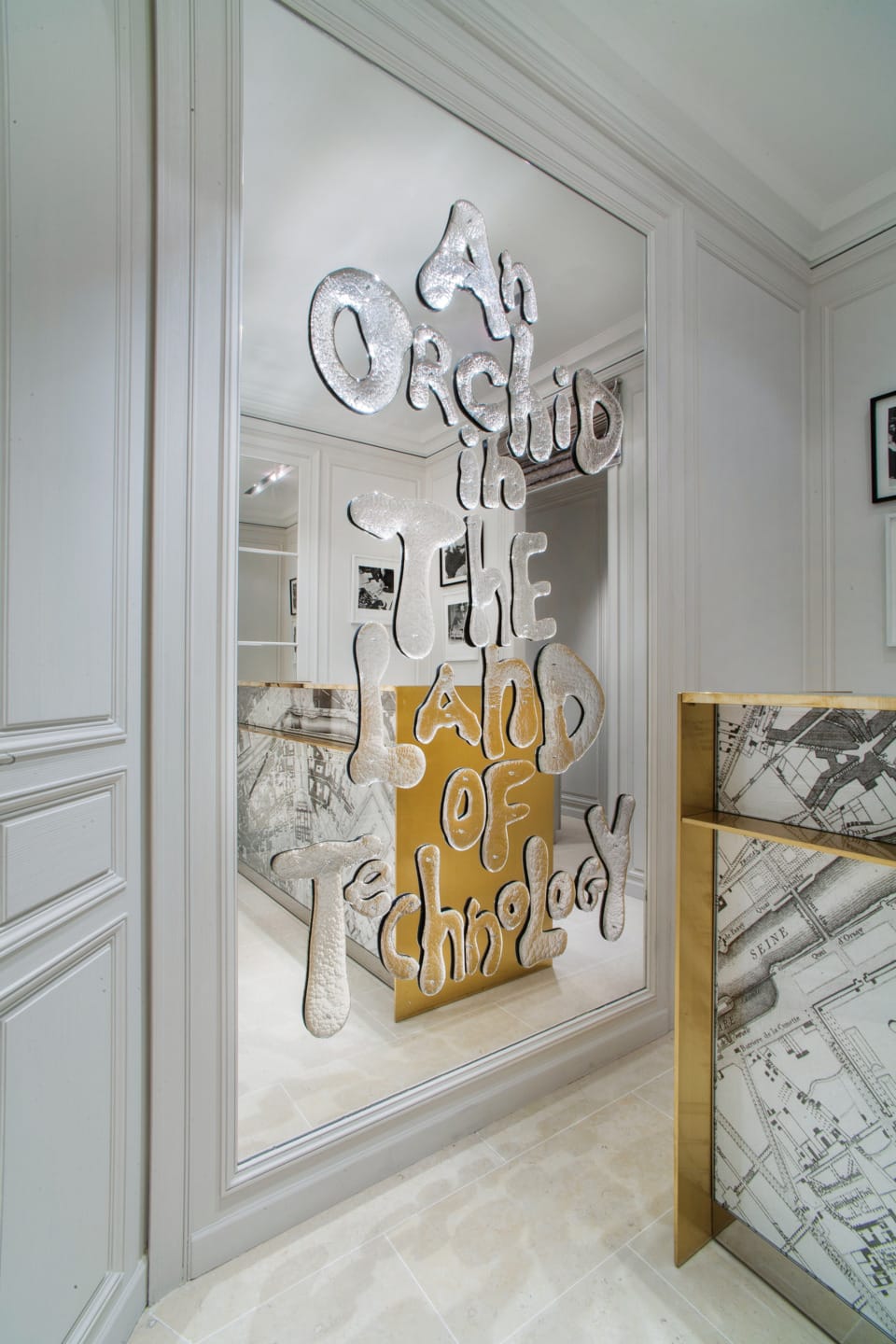 Decorative mirror with the phrase "An Orchid in the Land of Technology" embossed in a modern room setting.