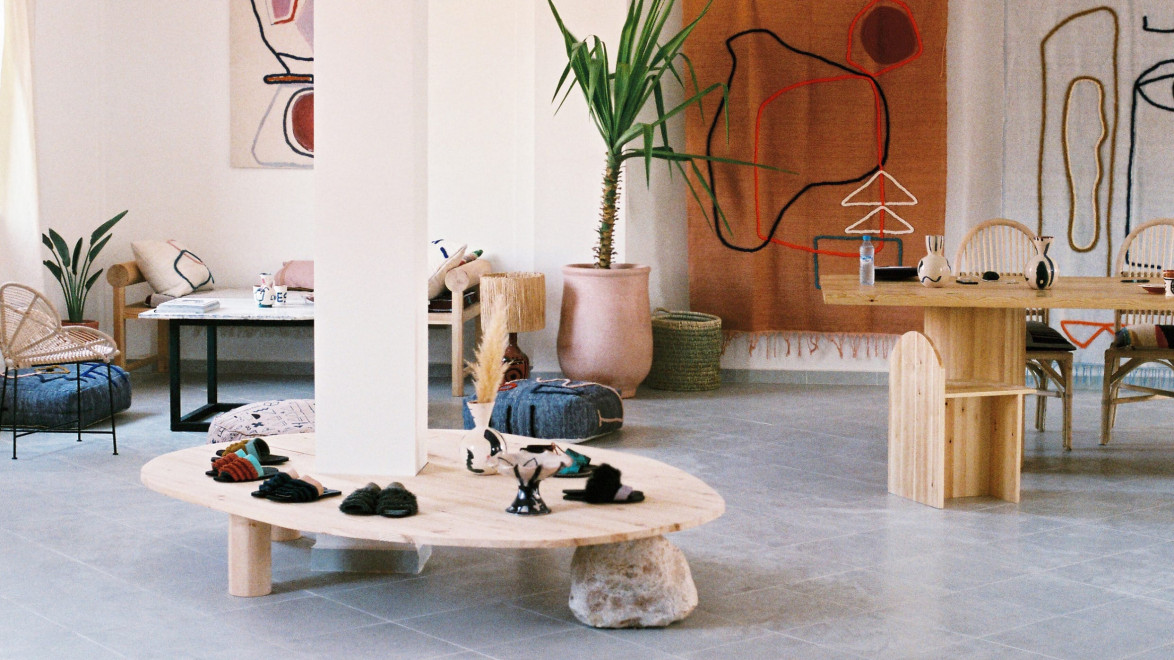 Modern minimalist living room with abstract art, wooden furniture, and natural decor elements.