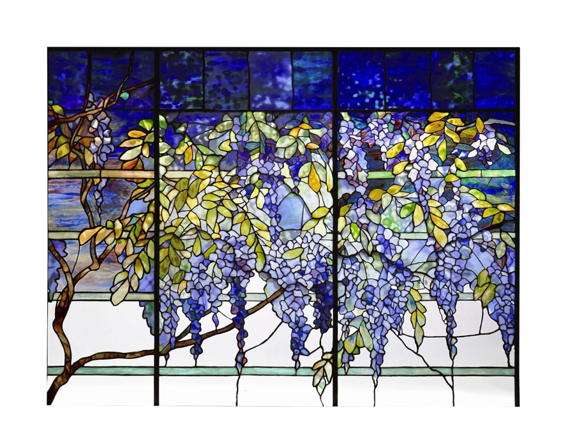 Stained glass window with intricate purple wisteria flowers and green leaves against a blue background.