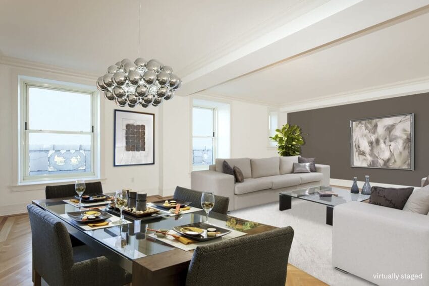 Modern living and dining room with elegant decor, glass table set for four, gray sofas, large abstract paintings.