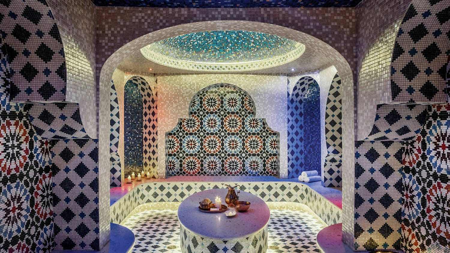 ornate interior of a traditional Turkish bathhouse with colorful mosaic tiles and arched ceilings
