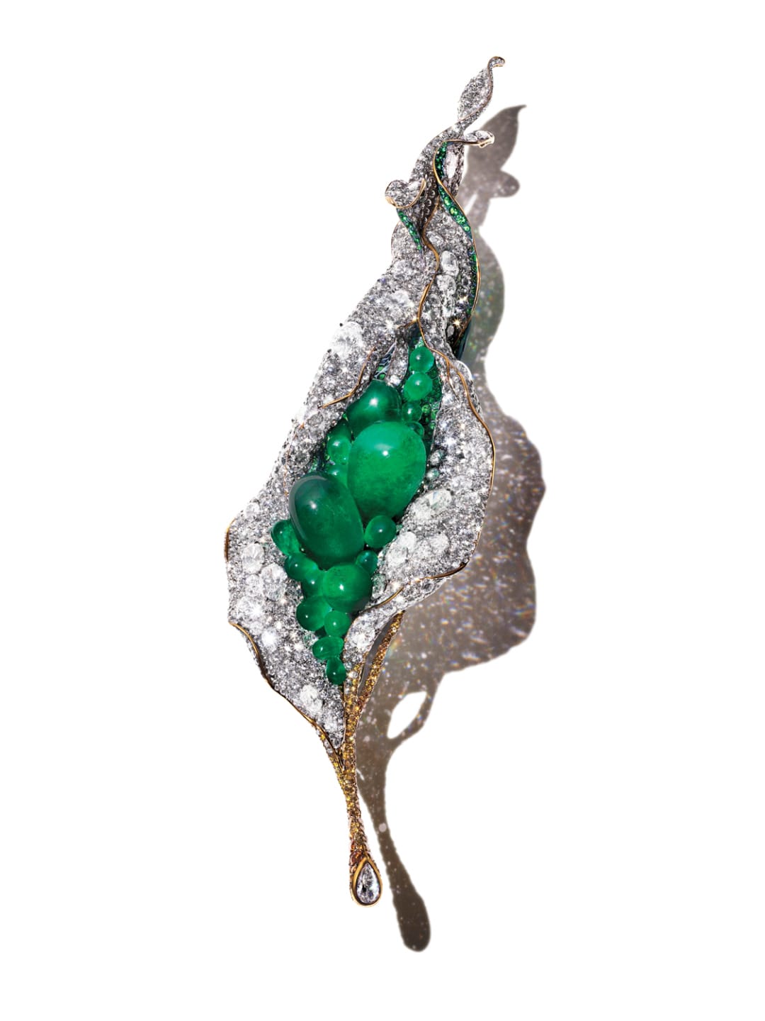 Artistic brooch with green stones and sparkling accents, resembling an abstract leaf design with a droplet at the tip.