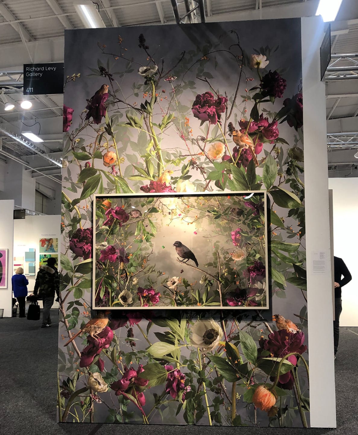 vivid floral artwork with birds on display at an art gallery exhibition