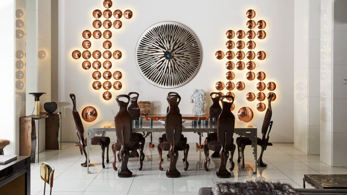 Dining room with unique wooden chairs, decorative plates on walls, and a large, circular patterned artwork in the center.