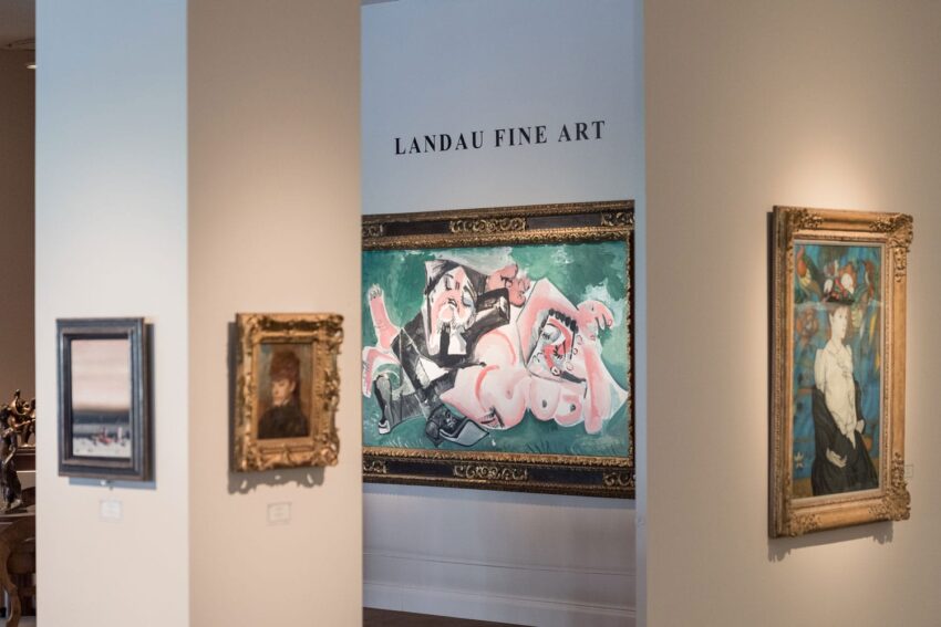 Paintings displayed in an art gallery, with a large colorful artwork in the center, under a sign reading "Landau Fine Art".