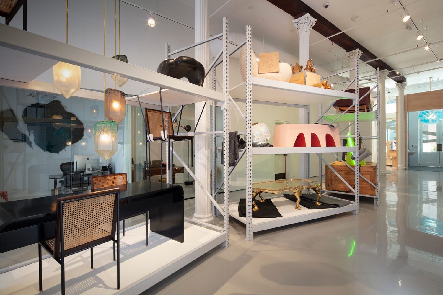 Modern interior with stylish furniture on display in a showroom setting, featuring shelves and contemporary lighting fixtures.