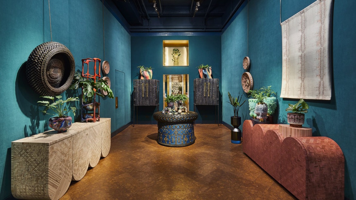 Eclectic room with vibrant blue walls, patterned furniture, plants, and decorative art pieces creating a cozy atmosphere.