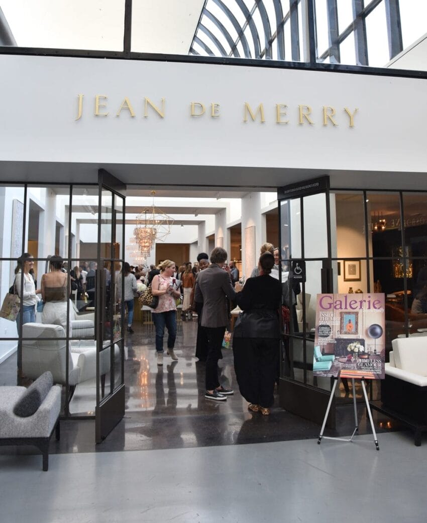 People socializing at a Jean de Merry event entrance with modern interior and decorative elements.