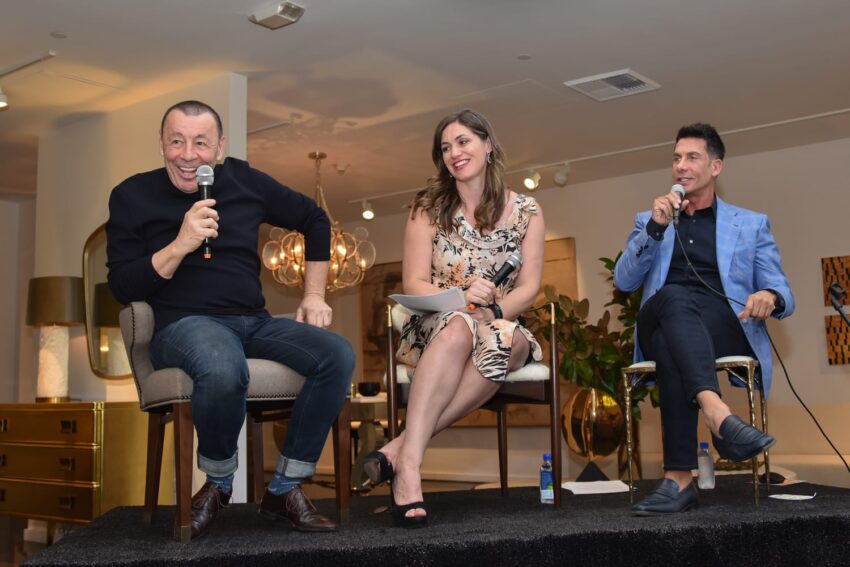 Three people sitting and speaking into microphones during a panel discussion inside a well-lit room.