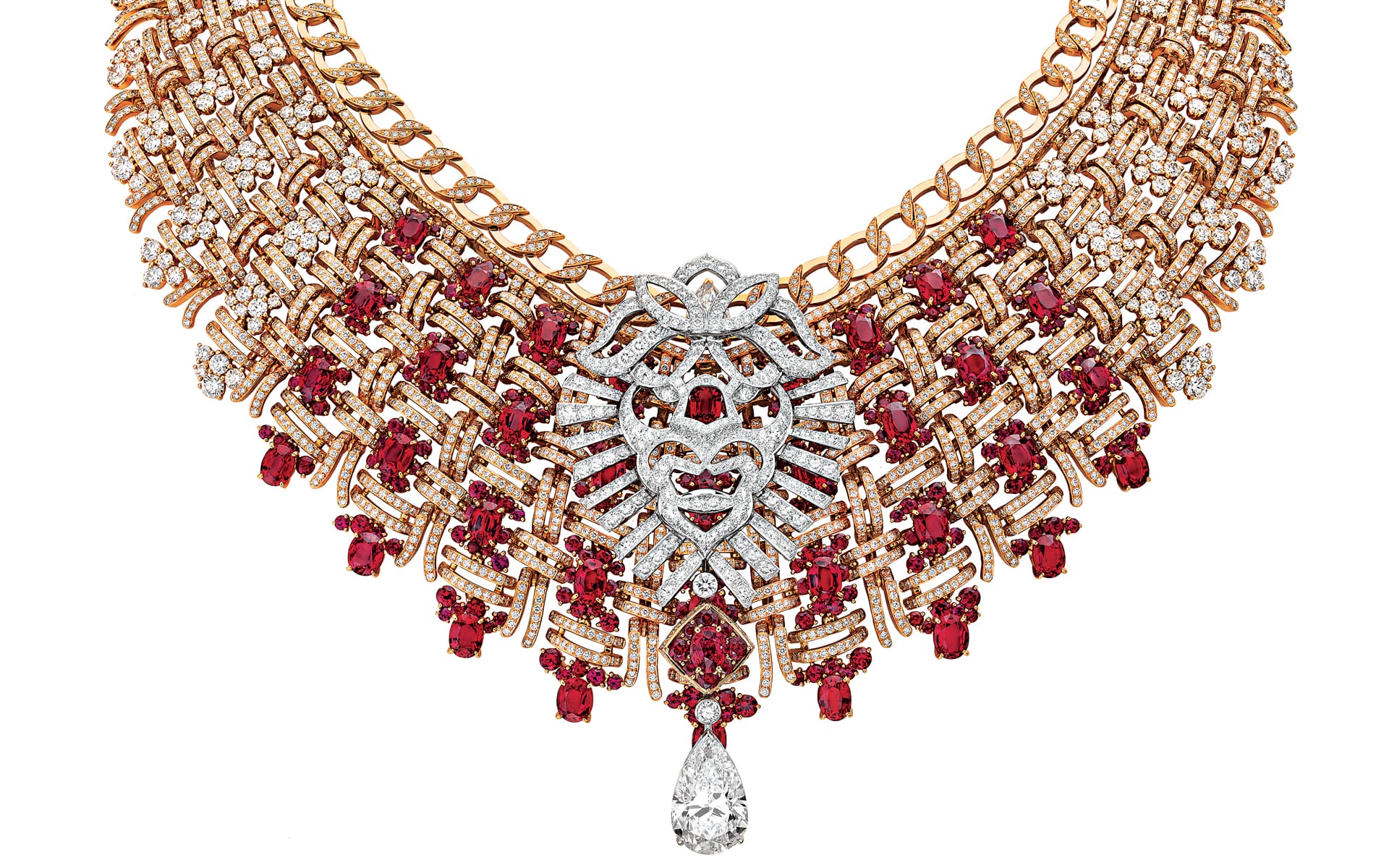 Intricate gold necklace with red gemstones and a teardrop-shaped diamond centerpiece, featuring a detailed filigree design.