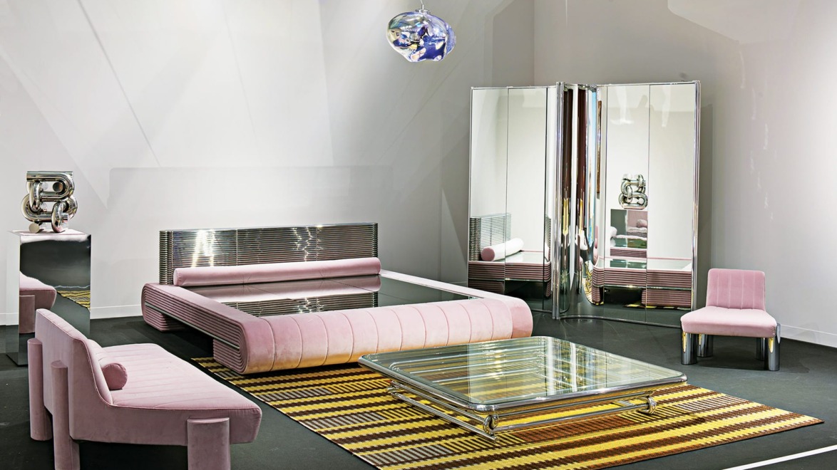 Modern room with pink velvet furniture, reflective surfaces, striped rug, and unique lighting fixture.