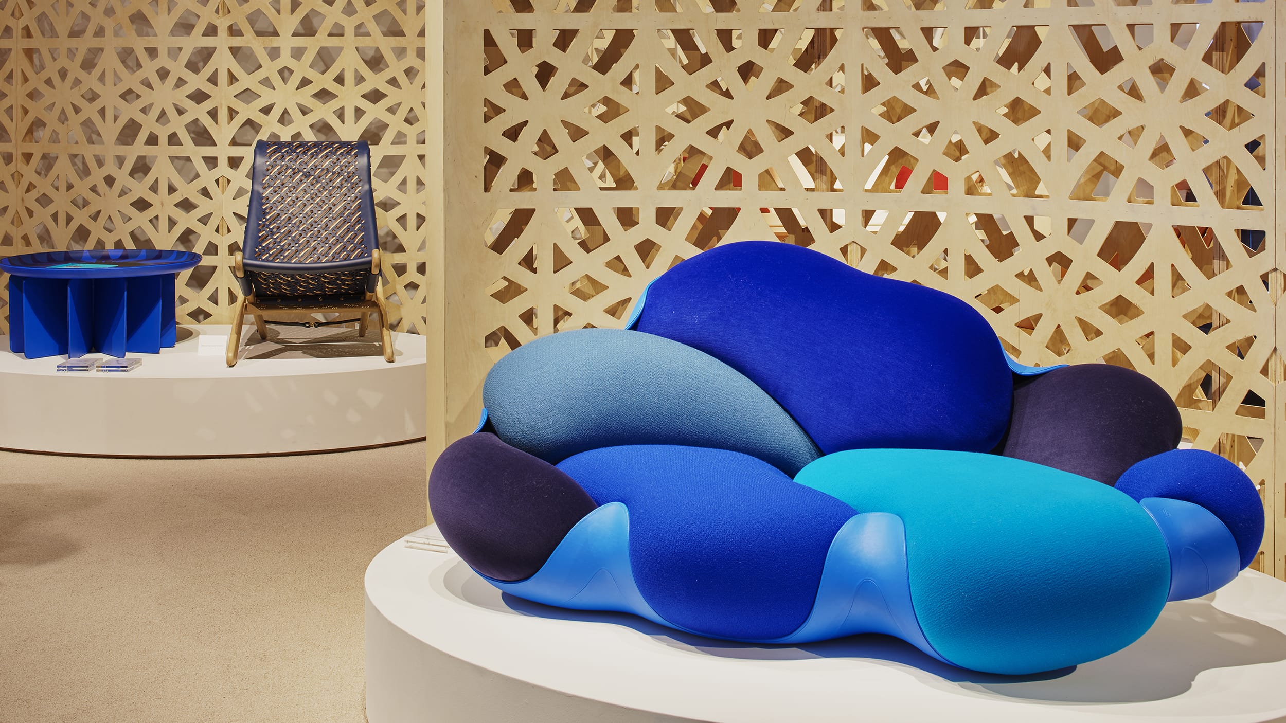 Modern showroom featuring a bold, abstract blue couch with geometric patterns and unique furniture on display.