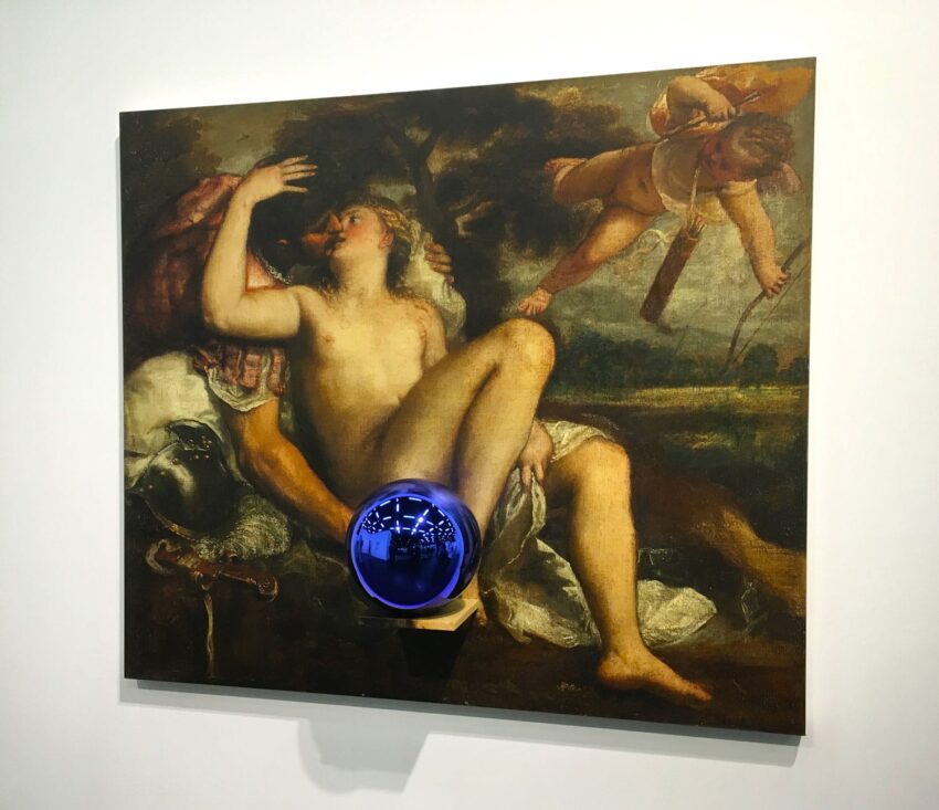 Renaissance-style painting with blue reflective sphere and winged figure aiming an arrow at a seated person.