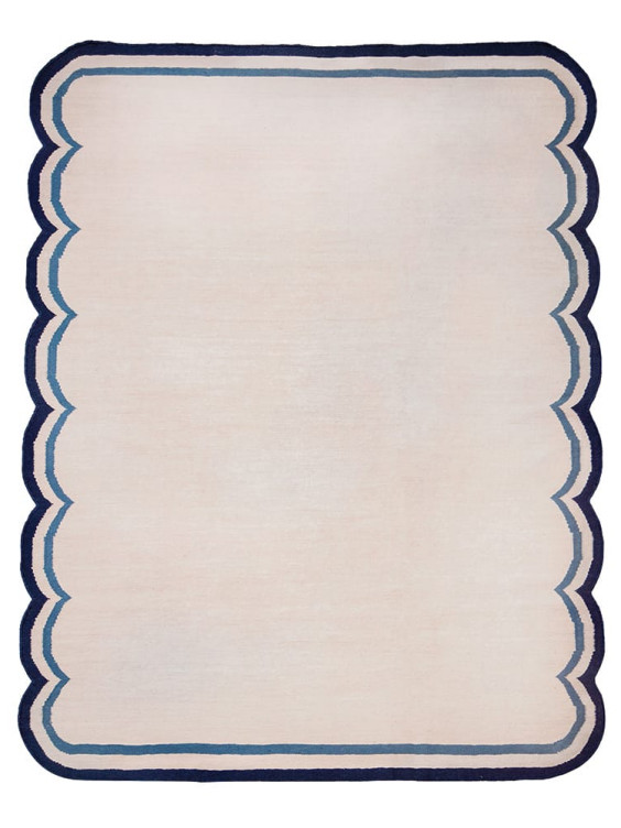 Beige rug with scalloped edges and a navy border.