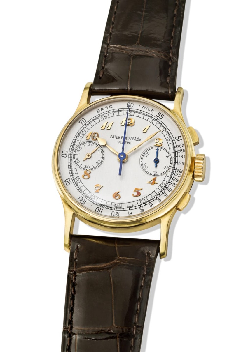 Gold vintage wristwatch with a crocodile leather strap, featuring a white face and blue and gold accents.