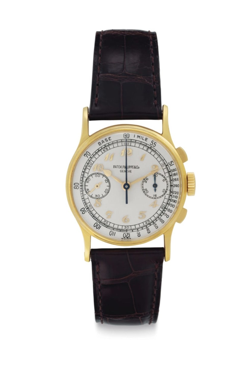 Luxury gold wristwatch with black leather strap and a detailed analog face displaying multiple subdials and intricate markings.