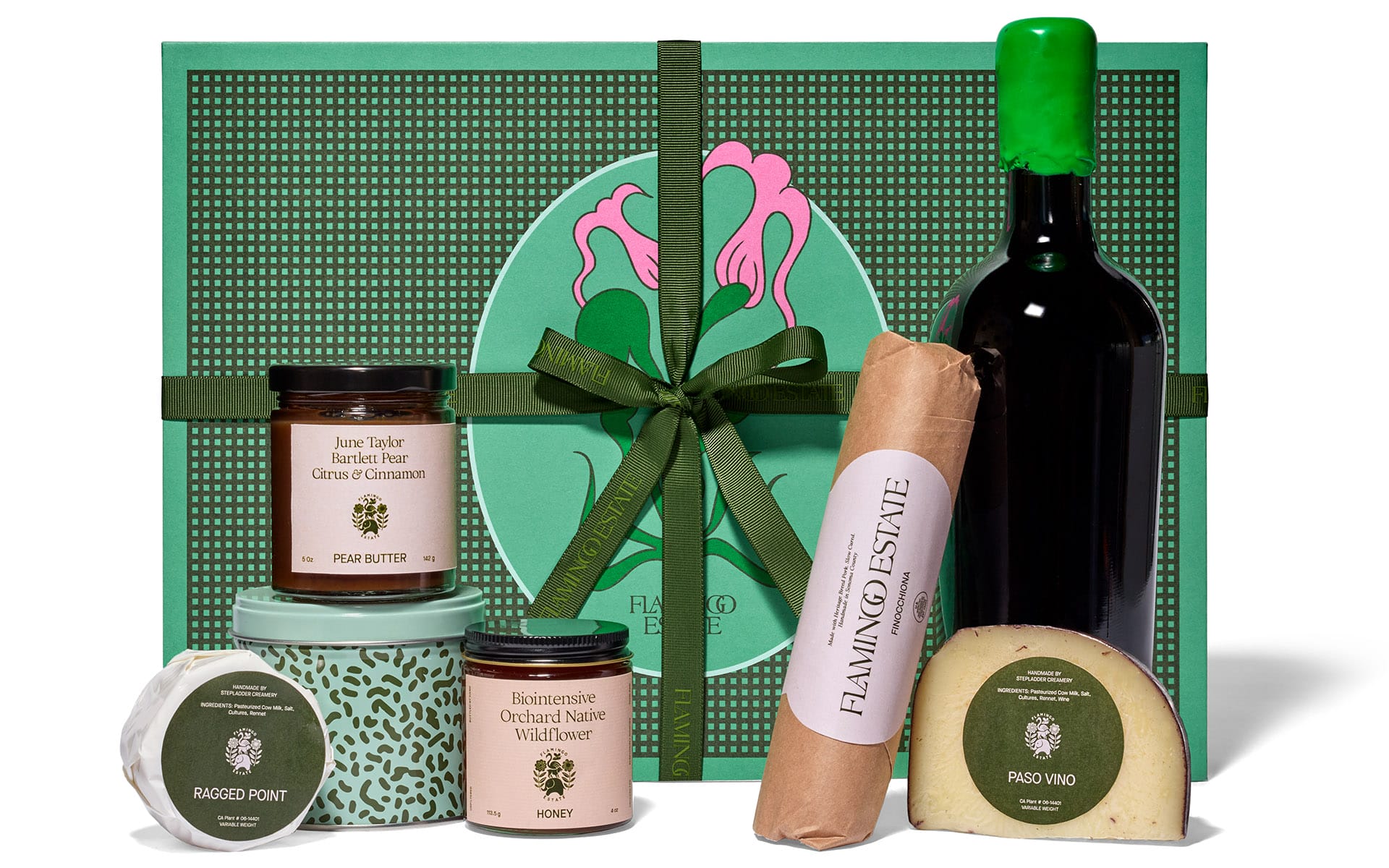 Gift box with wine, cheese, honey, pear butter, and luxury food items set against a green decorative backdrop.