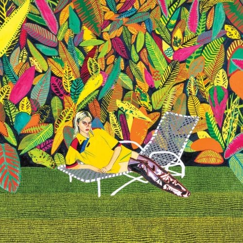 Person lounging on a patterned chair in front of a vibrant, colorful leaf mural.