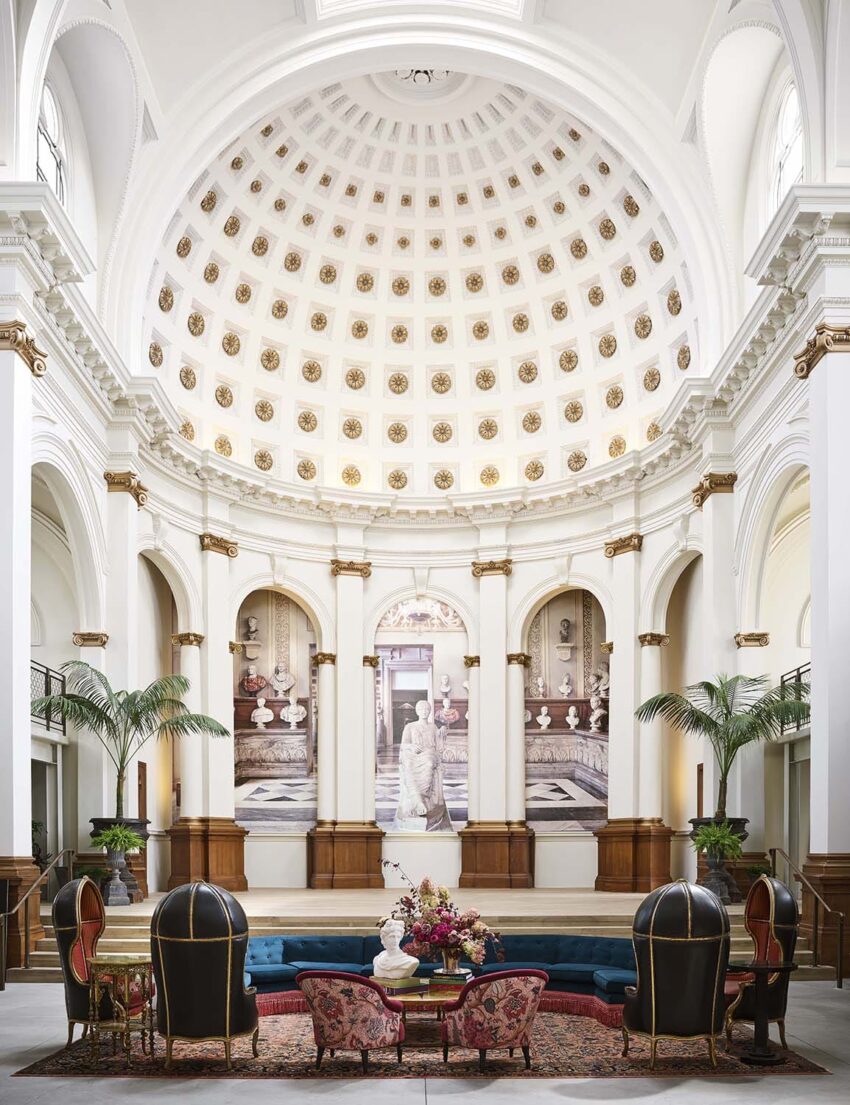 Elegant hotel lobby with a grand domed ceiling, luxurious seating, and classical decor elements.