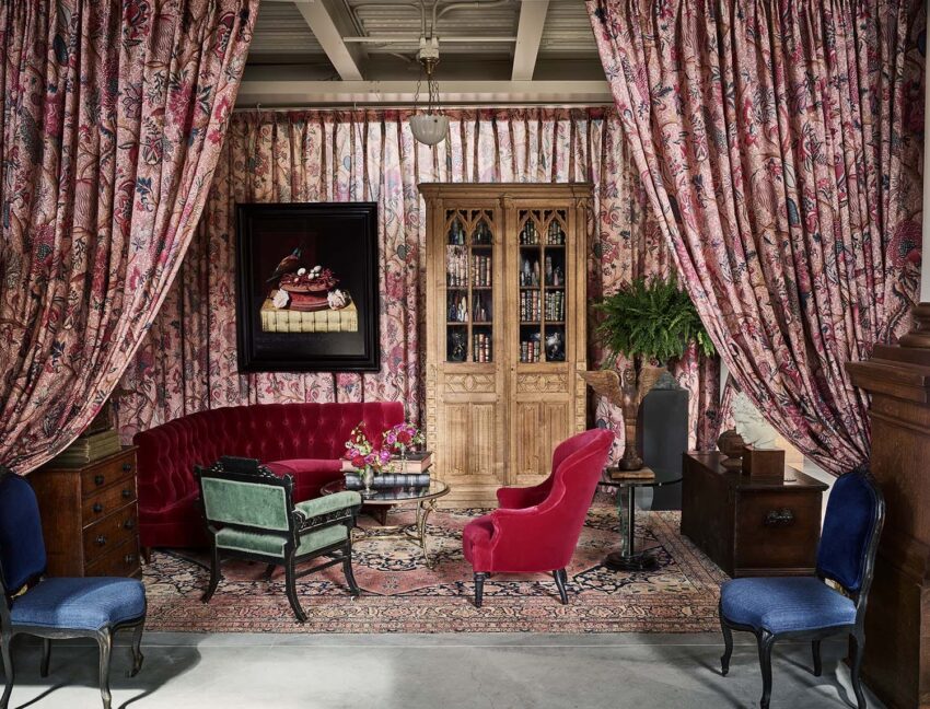 Vintage room with red velvet furniture, floral curtains, wooden cabinet, and ornate rug. Classic and elegant interior design.