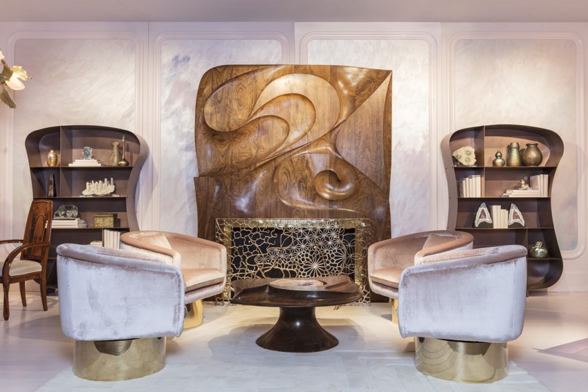 Luxurious living room with art deco design, featuring plush chairs, wooden bookcases, sculpted fireplace, and decorative accents.