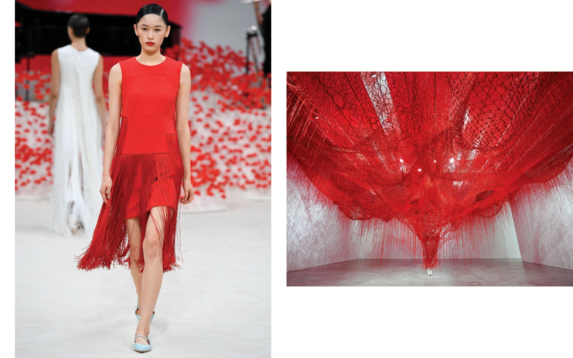Model in red dress on runway next to red abstract art installation in gallery setting.