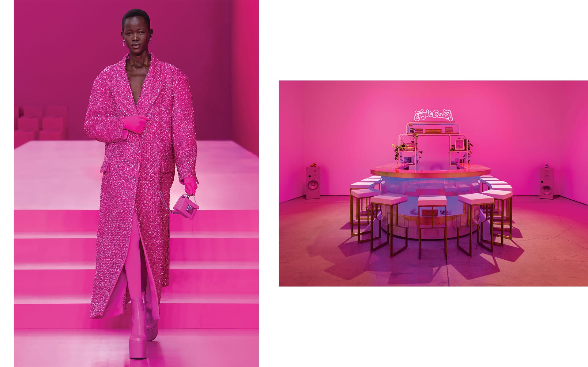 Model in a long pink coat on a runway, next to a pink-themed room with a circular table and stools.
