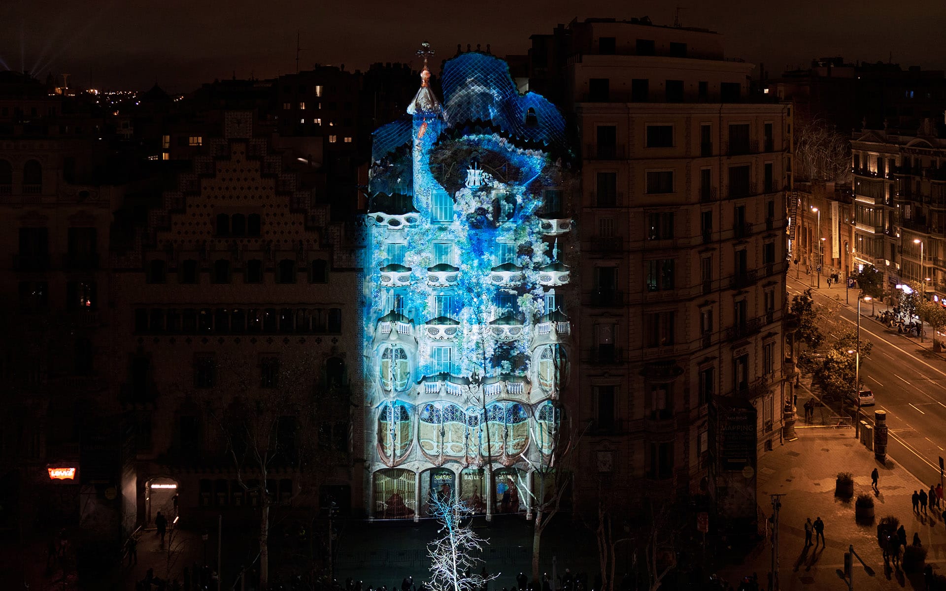 Night view of a building with colorful light projections in a city setting against a dark sky.