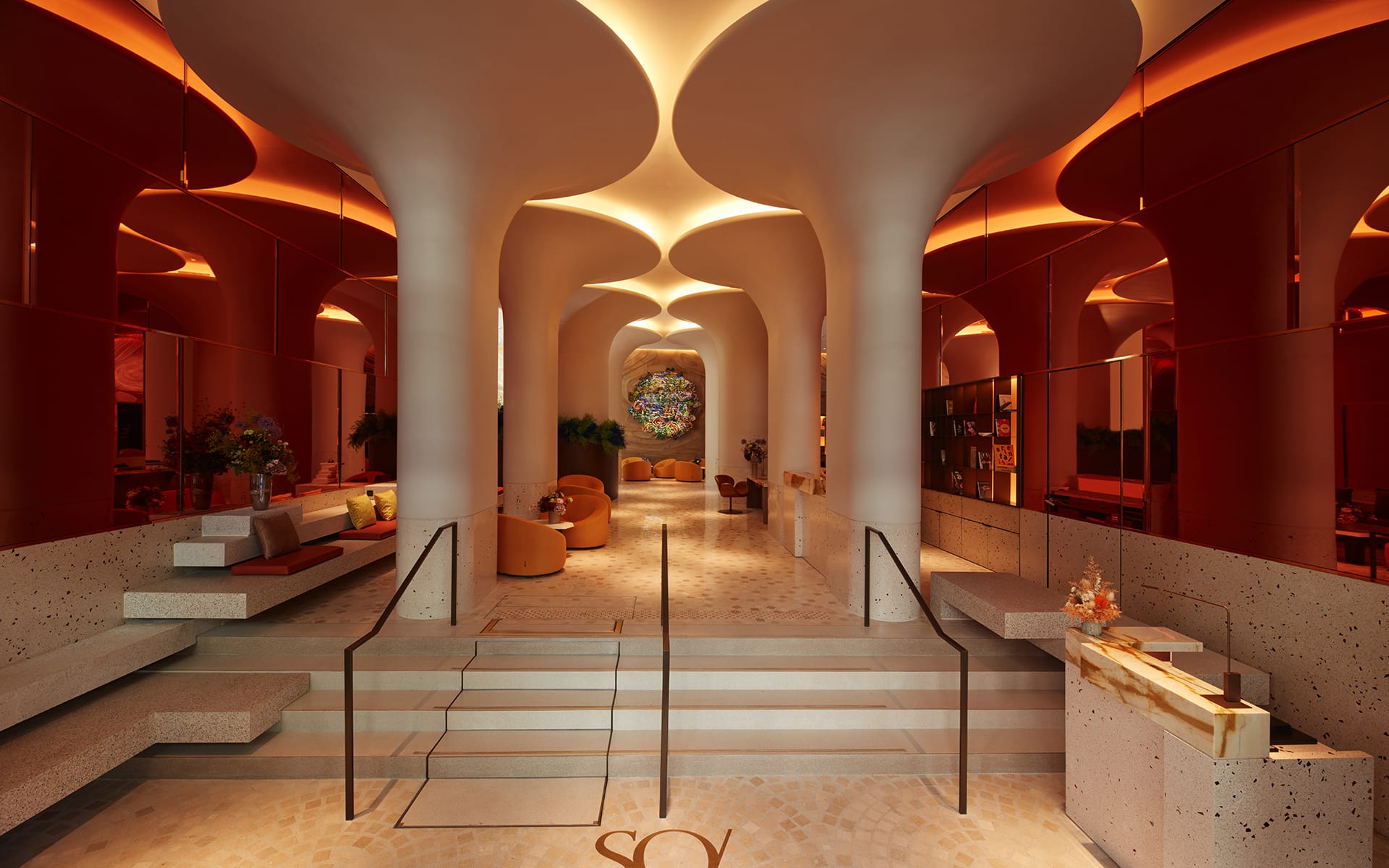 A modern lobby with unique curved columns, warm lighting, and stylish seating areas creating a welcoming ambiance.