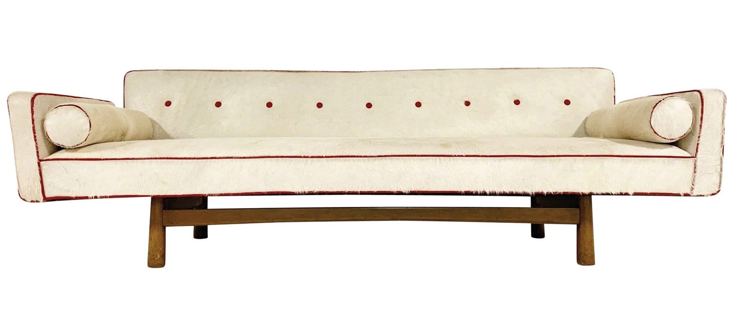 Mid-century modern cream sofa with red accents and cylindrical armrests on a wooden frame.