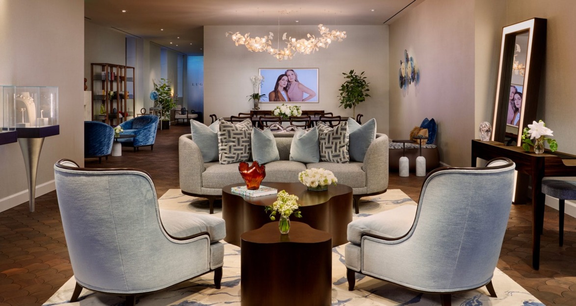 Modern living room with elegant blue chairs, a plush sofa, decorative lighting, and framed art on the wall.