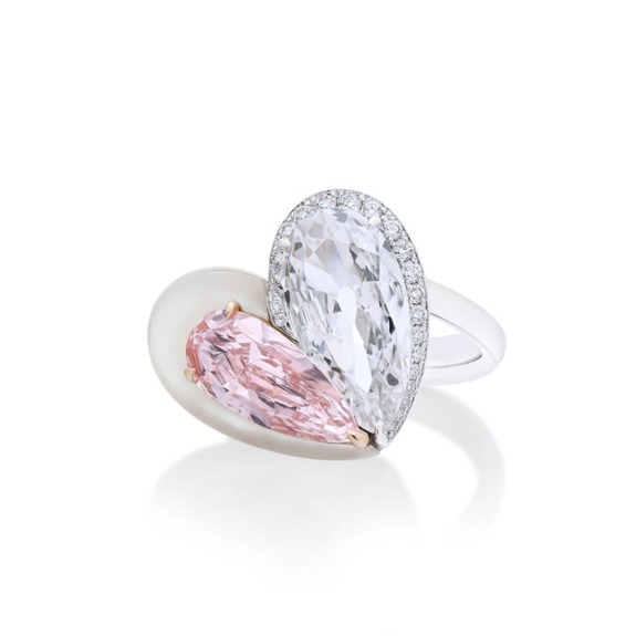 Elegant ring with pink and clear pear-shaped gemstones, set in a white band, displayed on a white background.
