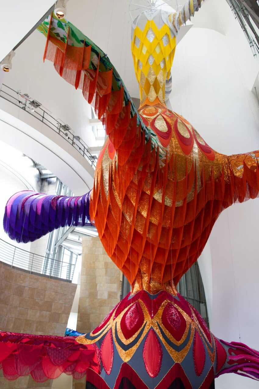 Colorful, large-scale sculpture with intricate patterns and textures displayed in a modern architectural setting.
