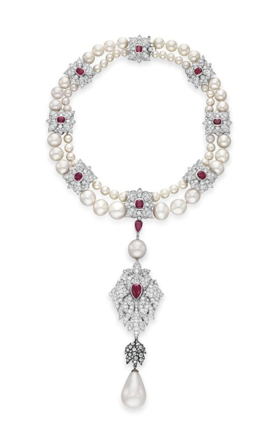 Elegant necklace with pearls, rubies, and diamonds, featuring a teardrop pearl pendant against a white background.